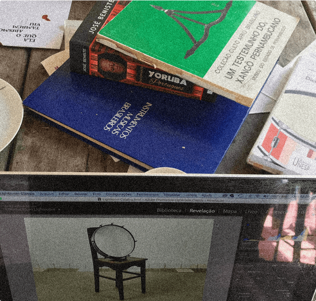 Notebook e livros em cima de uma mesa