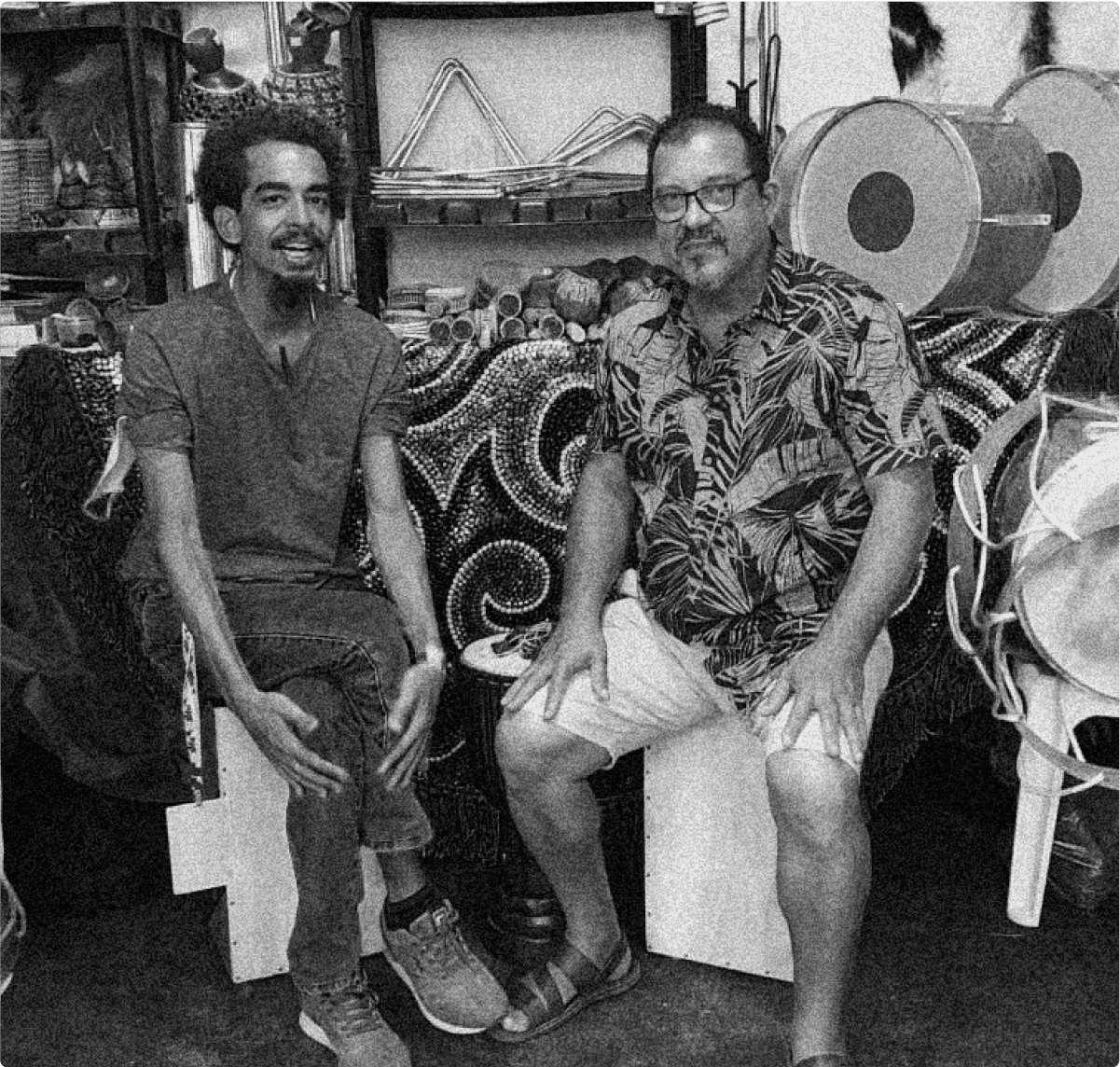 Hassan e Abílio sentados com instrumentos ao fundo